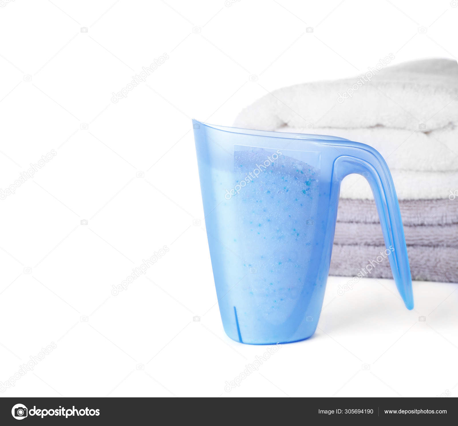 Laundry detergent in plastic measuring cup and towels on white background  Stock Photo by ©NewAfrica 305694190
